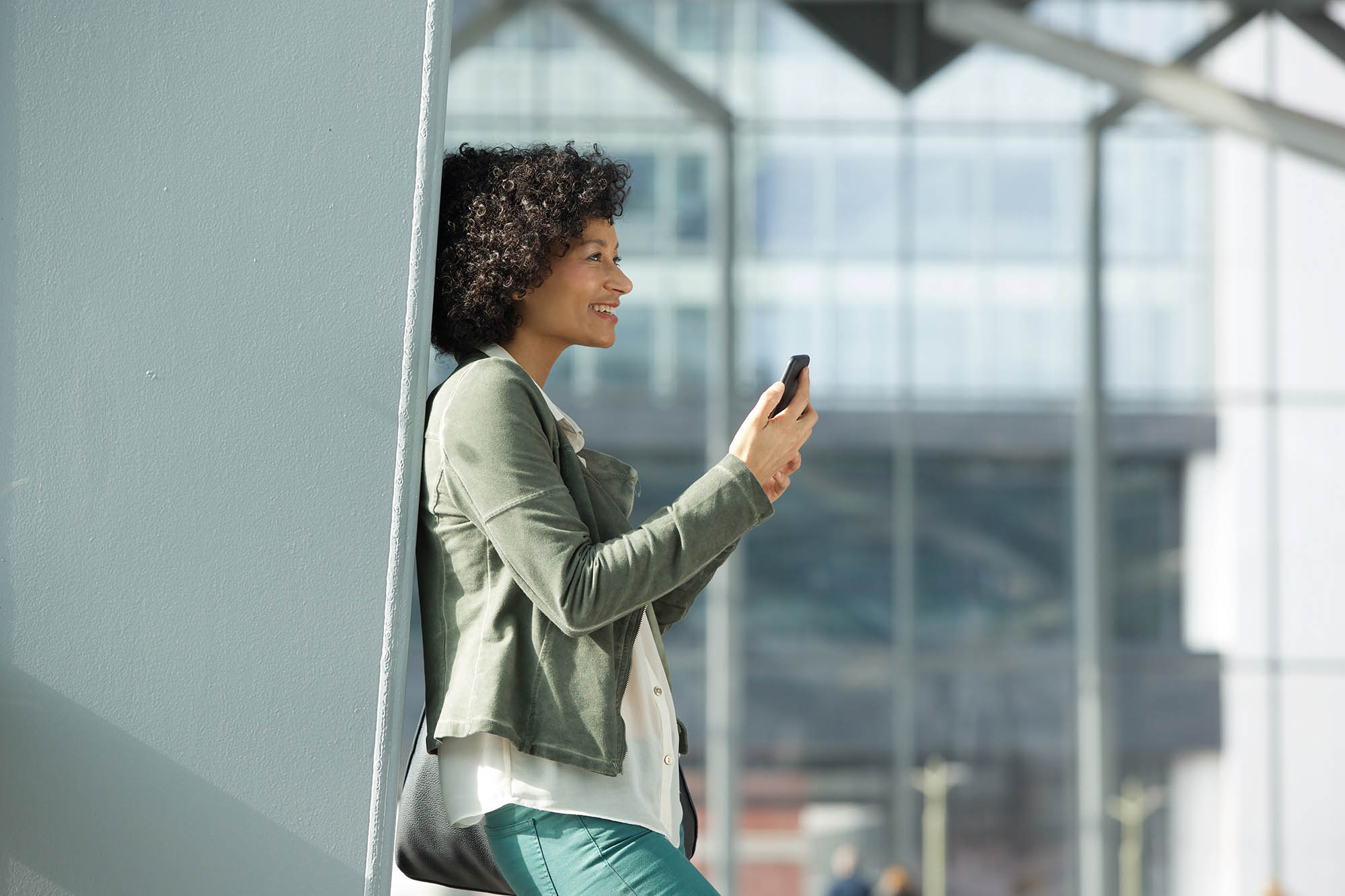 Side portrait of happy african american woman with mobile phone
