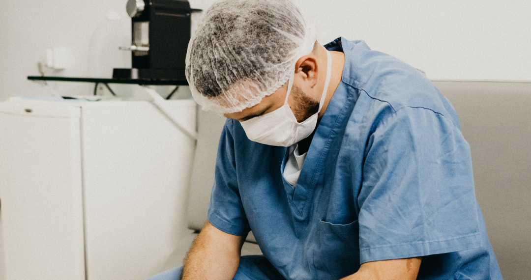 nurse sitting on couch looking down